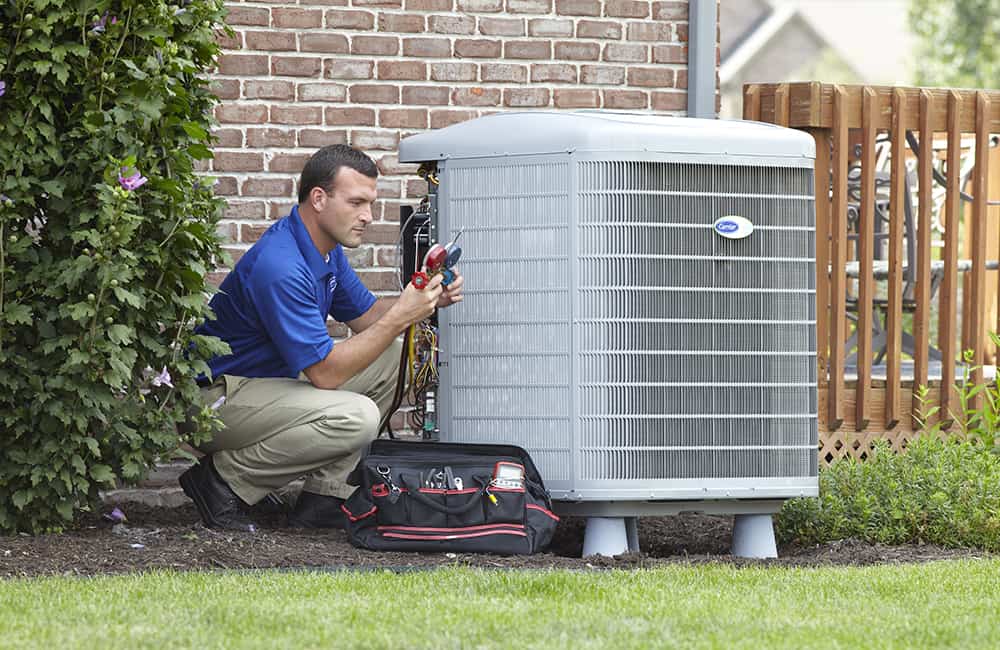 Technician working on carrier unit | Advanced Heating and Air Conditioning