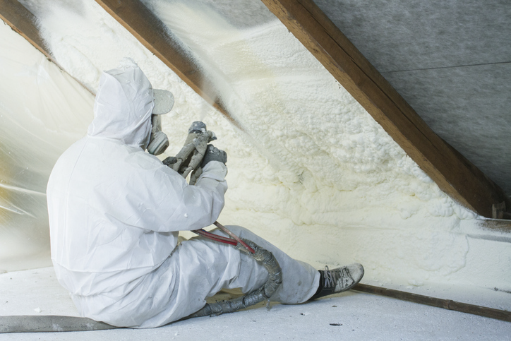 technician spraying foam insulation using plural component gun for polyurethane foam, inside | Advanced Heating and Air Conditioning