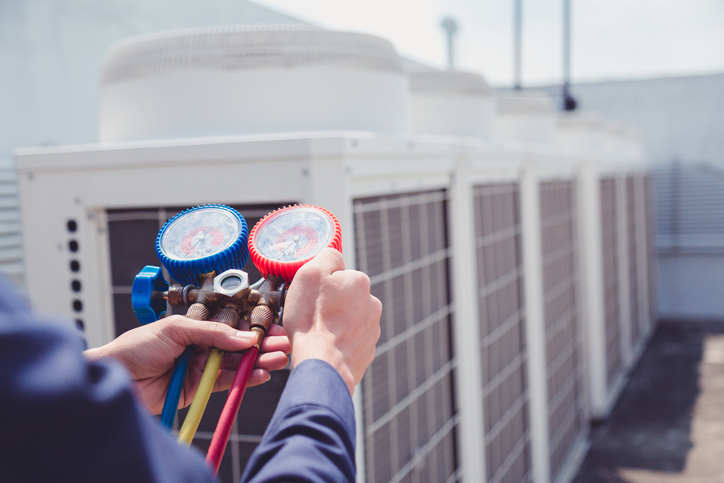 Technician is checking air conditioner ,measuring equipment for filling air conditioners. | Advanced Heating and Air Conditioning