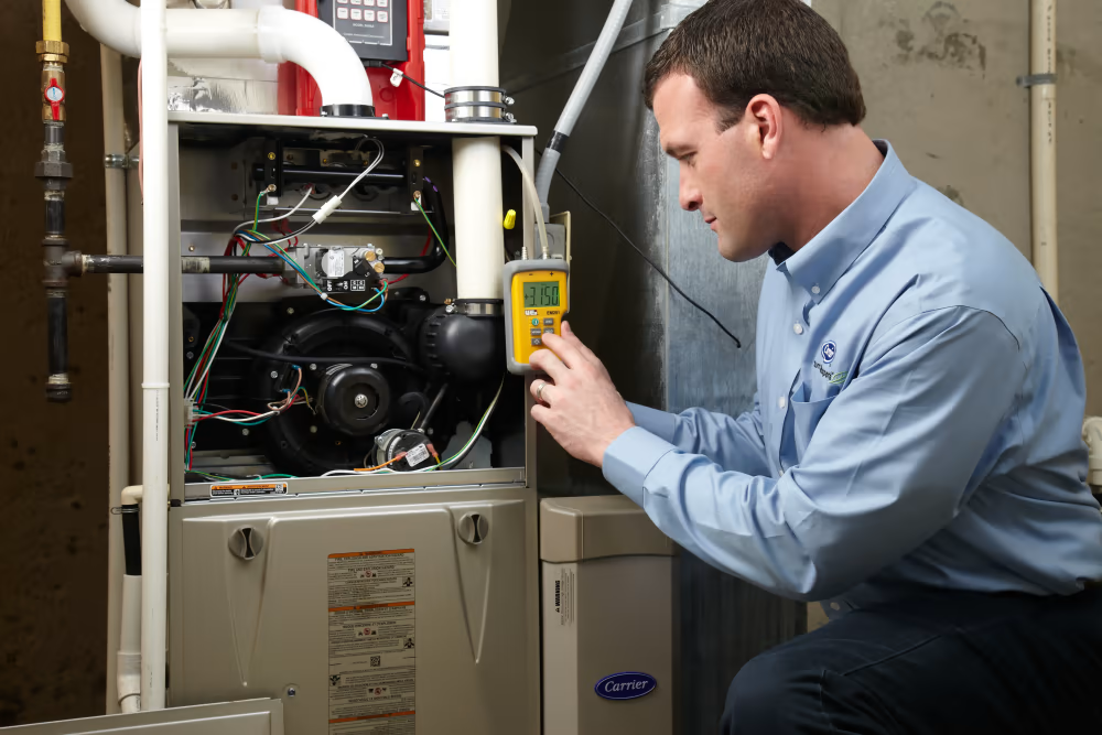carrier technician servicing furnace unit | Advanced Heating and Air Conditioning