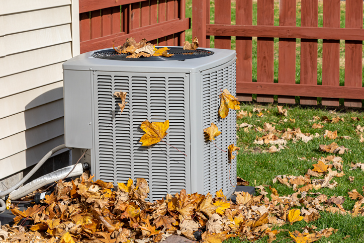 Dirty air conditioning unit covered in leaves during autumn. | Advanced Heating and Air Conditioning