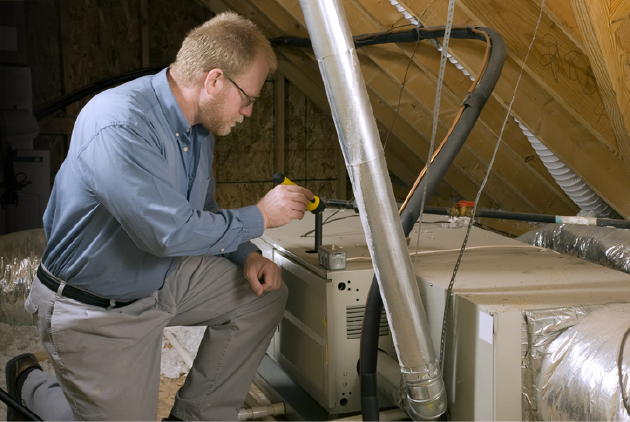 Service Tech Inspects Furnace | Advanced Heating and Air Conditioning